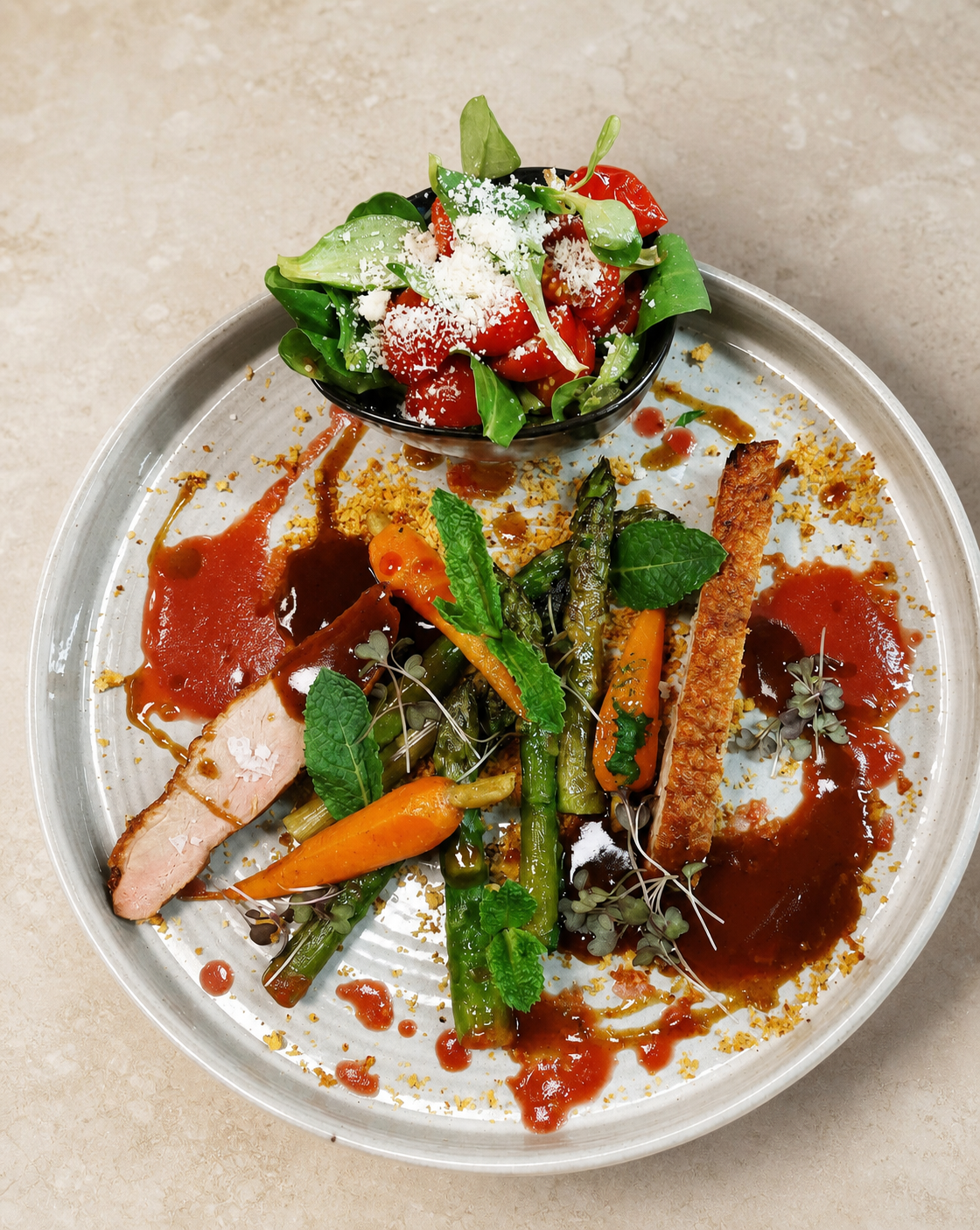 Meat with asparagus, carrots and tomato salad